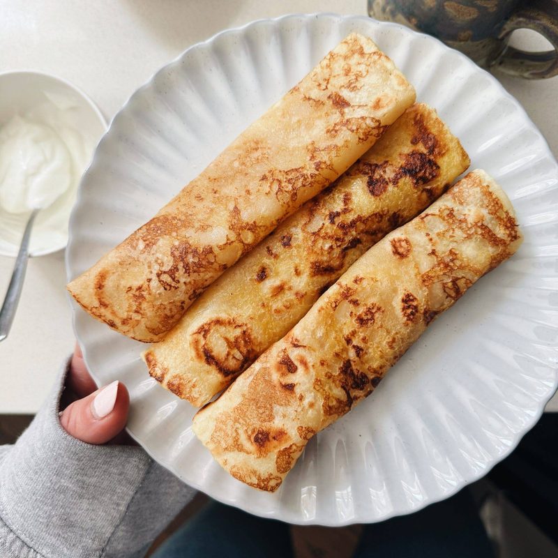 French toast crepes rolled on a plate.