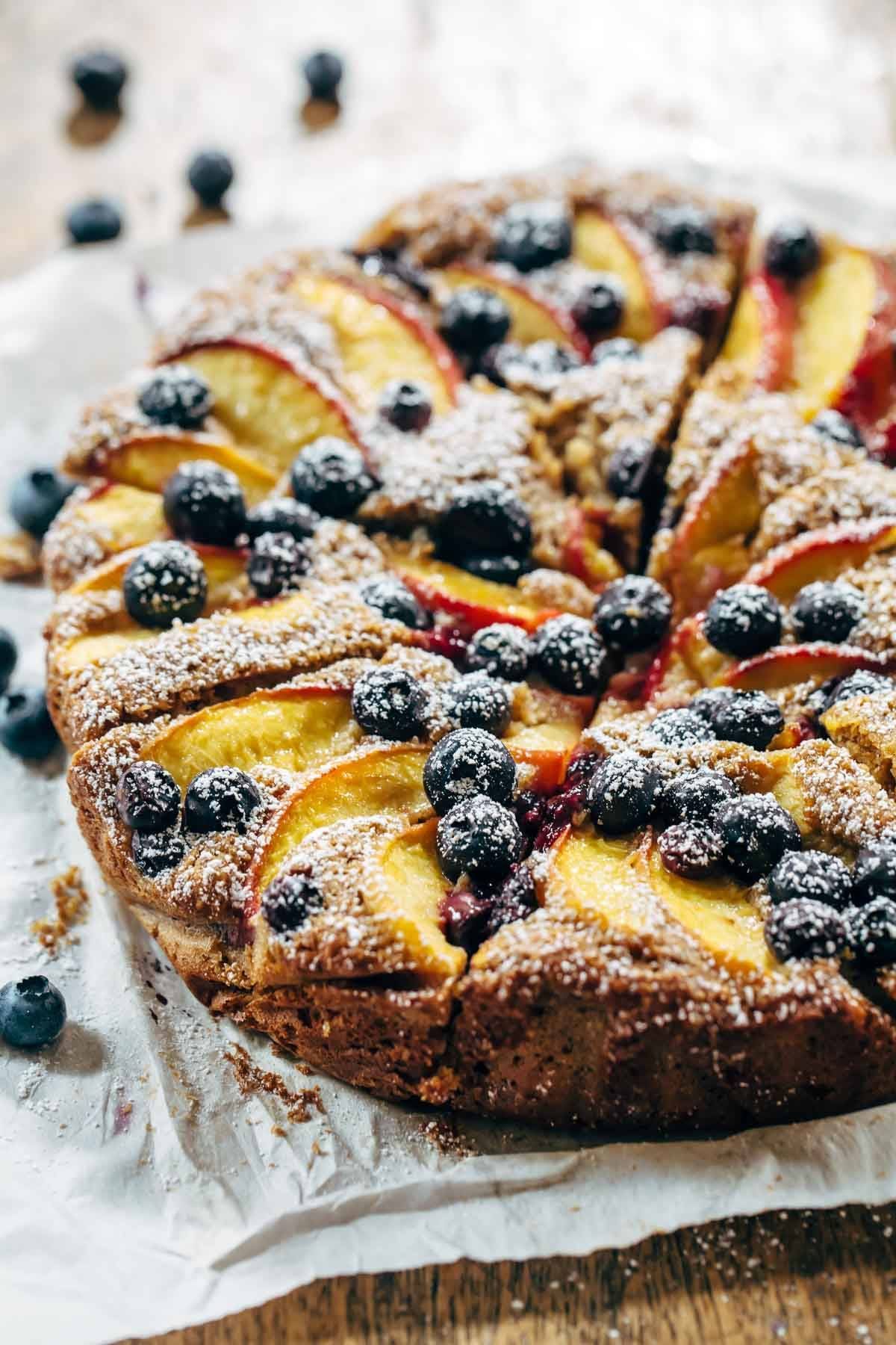 Blueberry Peach Cake recipe uses simple ingredients, whole wheat, no refined sugar, and has a STUNNING presentation. YUM! | pinchofyum.com A blueberry peach cake on a towel.