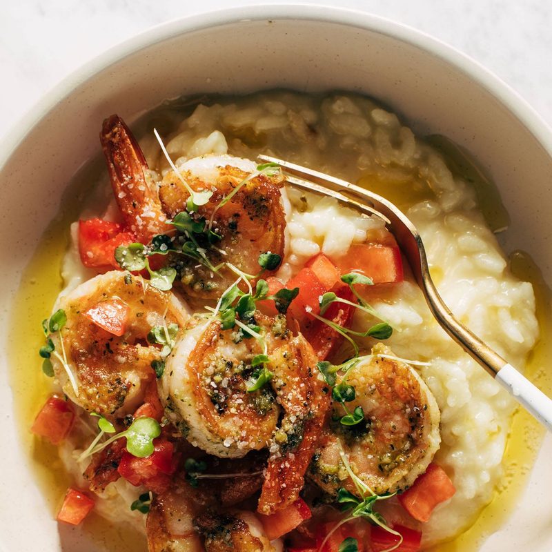 Pesto shrimp with risotto and a fork in a bowl