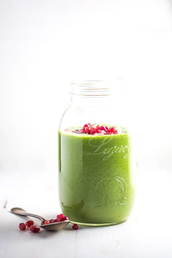 Green apple smoothie with pomegranate seeds.